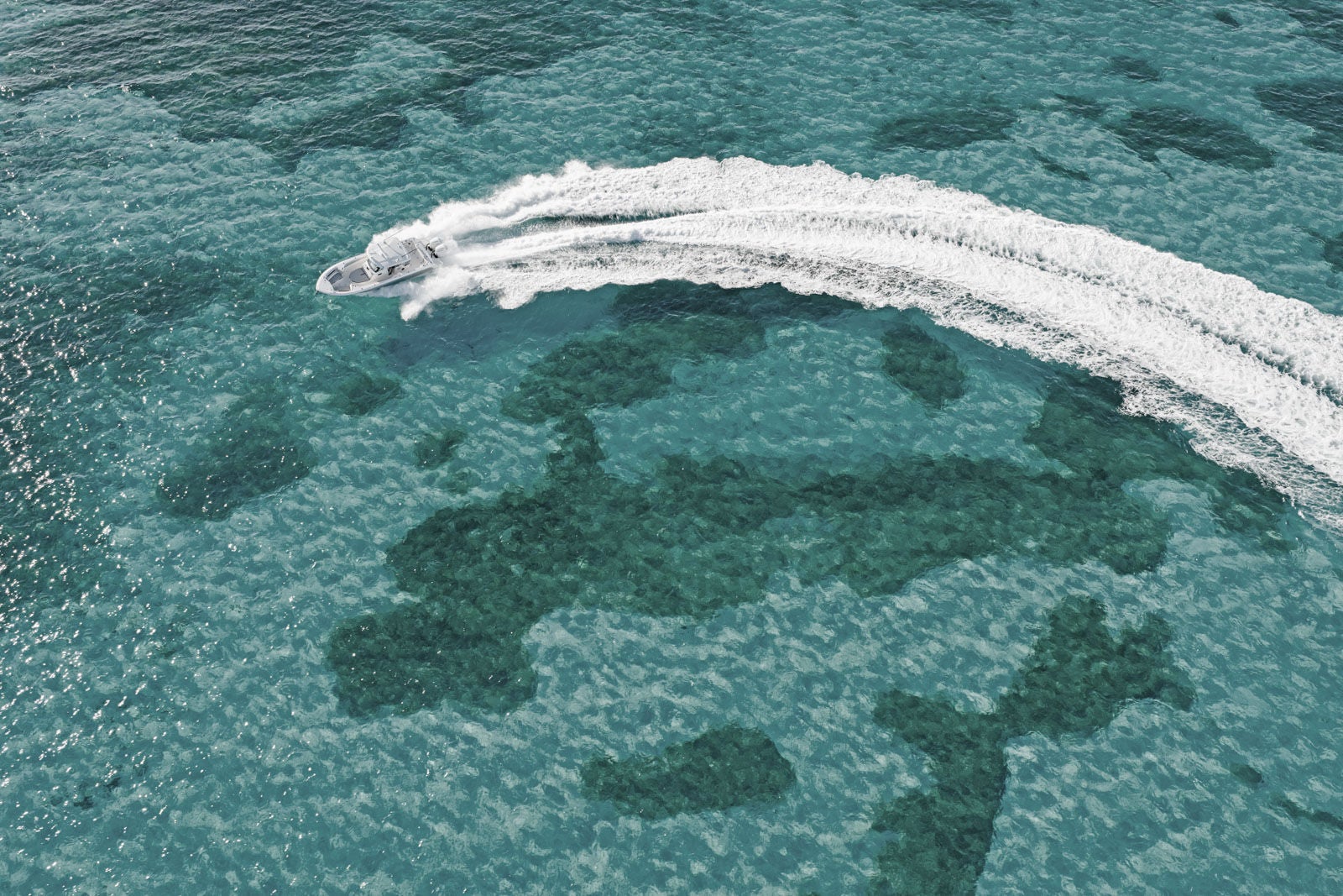 A 330 Outrage circles in shallow clear water.